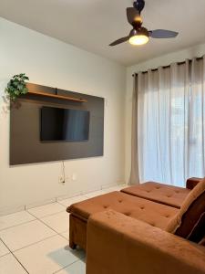 ein Wohnzimmer mit Sofa und Flachbildfernseher in der Unterkunft Ap Conforto no Centro de Sinop in Sinop