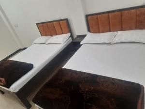 two beds sitting next to each other in a room at annpurna home stay in Ujjain