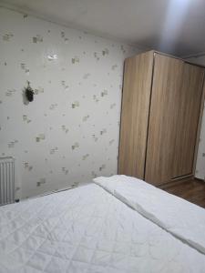 an empty bedroom with a bed and a cabinet at Guest House Mao in Tbilisi City