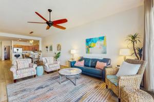 a living room with a couch and chairs and a ceiling fan at Harborview Grande 402 in Clearwater Beach