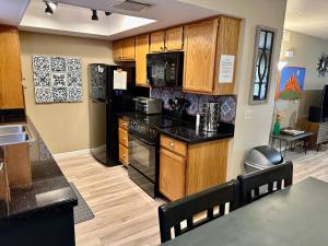 a kitchen with wooden cabinets and black appliances at Serenity Now in Beautiful Sedona - 3 BR 2 BA in Sedona