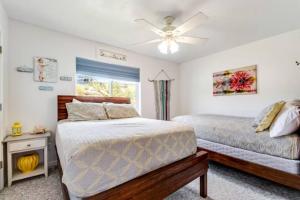 a bedroom with two beds and a ceiling fan at Sail Boat Manor in Garden City