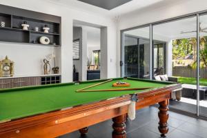 a pool table in a living room with glass doors at Pool Table and Resort Pool 4BR Holiday Paradise in Algester