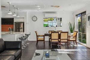 a kitchen and living room with a table and chairs at Pool Table and Resort Pool 4BR Holiday Paradise in Algester