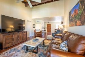 ein Wohnzimmer mit einem Ledersofa und einem Flachbild-TV in der Unterkunft Melanies Sedona Escape in Sedona