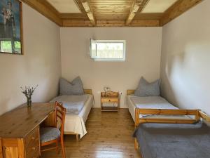 a room with two beds and a desk and a table at Lavender Apartment in Siófok +12 photos