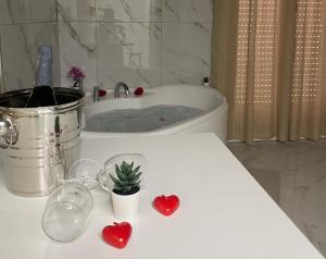 a bathroom with a tub with two hearts and a cactus at A quel paese rooms in Rosolini