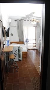 een kamer met een bed, een bureau en een tafel bij StudioAretiCom Studio to rent in FRONT the lovely SEA fully equipped plagiastudioseu in Nea Plagia