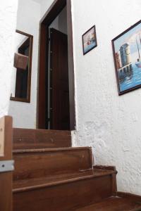 een trap met een deur en schilderijen aan de muur bij StudioAretiCom Studio to rent in FRONT the lovely SEA fully equipped plagiastudioseu in Nea Plagia
