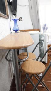 a table with two chairs and a blue vase on it at StudioAretiCom Studio to rent in FRONT the lovely SEA fully equipped plagiastudioseu in Nea Plagia