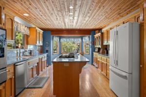a kitchen with a white refrigerator and wooden cabinets at Mountain Retreat Woodburning Fireplace Games in Big Bear City
