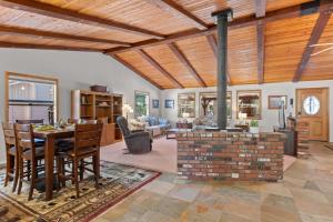 a dining room and living room with a brick fireplace at Mountain Retreat Woodburning Fireplace Games in Big Bear City