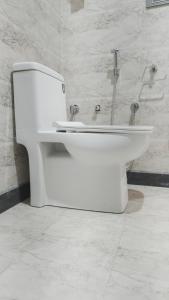 a bathroom with a white toilet in a room at Kanwar Villa Bir in Chauntrā
