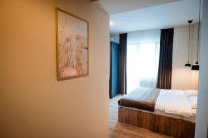 una camera da letto con un letto e un quadro sul muro di Fly&stay at George`s a Otopeni