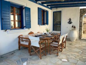 a table and chairs on a patio with blue shutters at Mediterranean Cottage in Ambelas