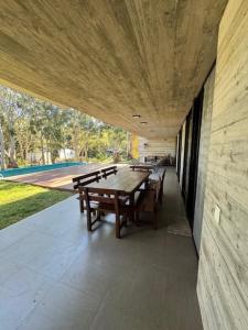 a wooden table and benches on a patio at Casa de lujo en Costa Esmeralda in Costa Esmeralda