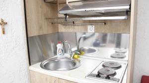 a kitchen with a sink and a stove at StudioAretiCom Studio to rent in FRONT the lovely SEA fully equipped plagiastudioseu in Nea Plagia +105 photos