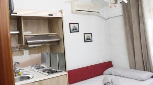 a small kitchen with a sink and a bed in a room at StudioAretiCom Studio to rent in FRONT the lovely SEA fully equipped plagiastudioseu in Nea Plagia