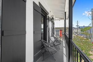 a balcony with two chairs on a house at Suite C Beach, Firepit, Dog-friendly, Downtown! in Biloxi