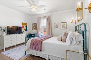 a bedroom with a bed with a ceiling fan and a tv at Suite C Beach, Firepit, Dog-friendly, Downtown! in Biloxi