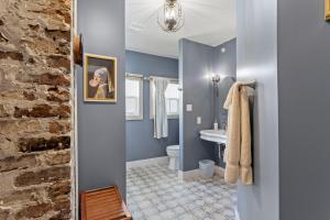 a bathroom with blue walls and a stone wall at Suite C Beach, Firepit, Dog-friendly, Downtown! in Biloxi +26 photos