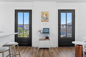 a room with two doors and a table with stools at Suite C Beach, Firepit, Dog-friendly, Downtown! in Biloxi