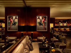 a restaurant with tables and a bar with pictures on the walls at The Surrey, A Corinthia Hotel in New York