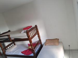 une chambre avec trois lits superposés et un canapé dans l'établissement Estúdio Mobiliado Condomínio da Fé Canção Nova apto 02, à Cachoeira Paulista