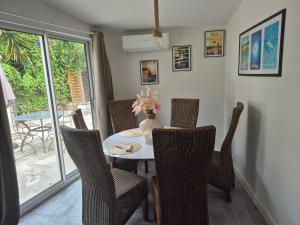 a dining room table with chairs and a vase with flowers at O'Soleil in Toulon