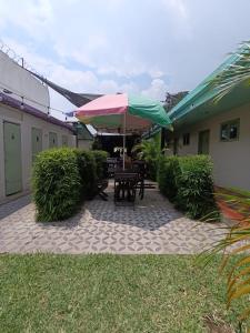 a patio with a table and an umbrella at El Ocote in Antigua Guatemala