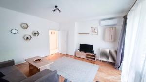 a living room with a couch and a tv at Május 1 apartman in Dunaújváros