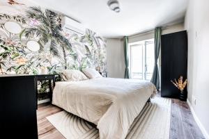 una camera da letto con un letto e carta da parati tropicale di Disney World a Villeneuve-le-Comte