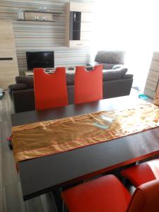 een woonkamer met een tafel met stoelen en een bank bij Solar Golden Beach Apartments in Siófok