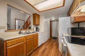 a kitchen with a sink and a refrigerator at Quiet 2-Bedroom Condo with Garage and Fast Wi-Fi in Fort Wayne +17 photos
