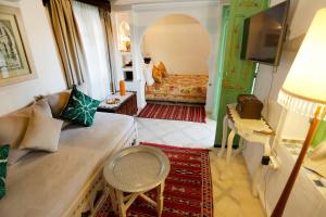 a living room with a couch and a bed at Riad Cherifa in Chefchaouene