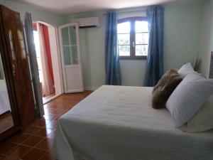 a bedroom with a bed with pillows and a window at Chez nous Cassis in Cassis