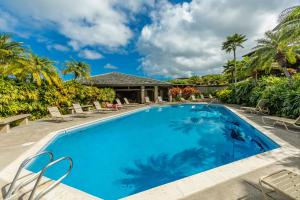 una piscina con sedie e palme di Kapalua Ridge Villas-#2212 by Coldwell Banker Island Vacations a Kahana