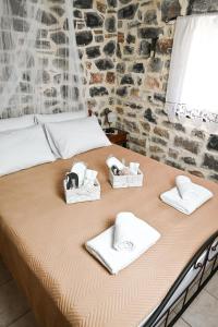 a bed with towels and hats on top of it at Zefki Stone Villa in Fodele