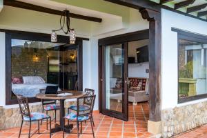 a patio with a table and chairs and a bedroom at Casa Edmond in Villa de Leyva