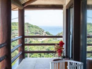 a room with a balcony with a view of the ocean at Pousada Ganesha in Búzios +17 photos