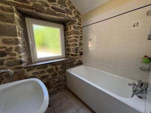 a bathroom with a bath tub and a window at BOILLOT, Trebeurden in a quiet area with sea view in Trébeurden +20 photos