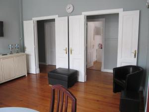 a living room with a table and chairs and a clock at Casa Azul Hostel in Sintra