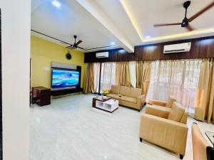 a living room with a couch and a tv at Katha Villa 63 - Luxury Holiday Home in Karjat