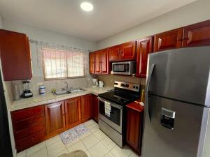 a kitchen with wooden cabinets and a stainless steel refrigerator at Casa Serena! in Coco