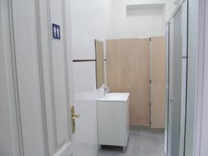 a white bathroom with a sink and a mirror at Casa Azul Hostel in Sintra