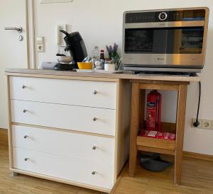 a microwave oven sitting on top of a dresser at Ferienwohnung Besenfelder in Notzingen
