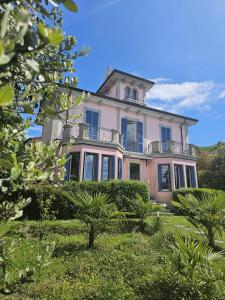a large pink house with a balcony on top of it at Villa Maria Lago Maggiore 2 in Leggiuno
