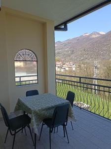 a table and chairs on a balcony with a view at Edera Hall Inclusive in Cerano d'Intelvi