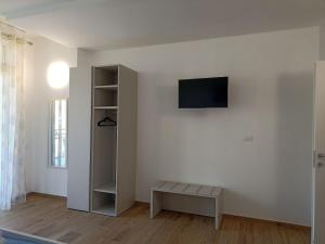 a living room with a tv on a white wall at Edera Hall Inclusive in Cerano d'Intelvi