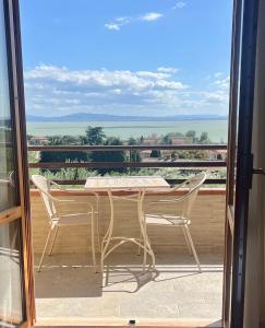 a table and chairs on a balcony with a view at La Casa Sul Lago - SlowLife in Passignano sul Trasimeno